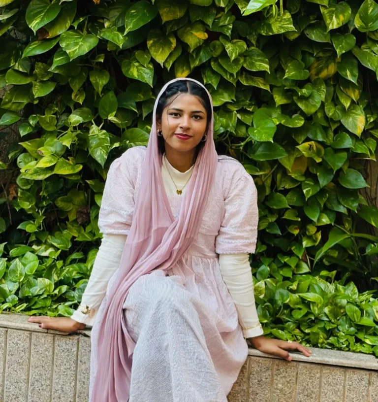 Freelance digital marketer in Thrissur | Kerala posing in a pink modest outfit and hijab against a lush green leafy background.